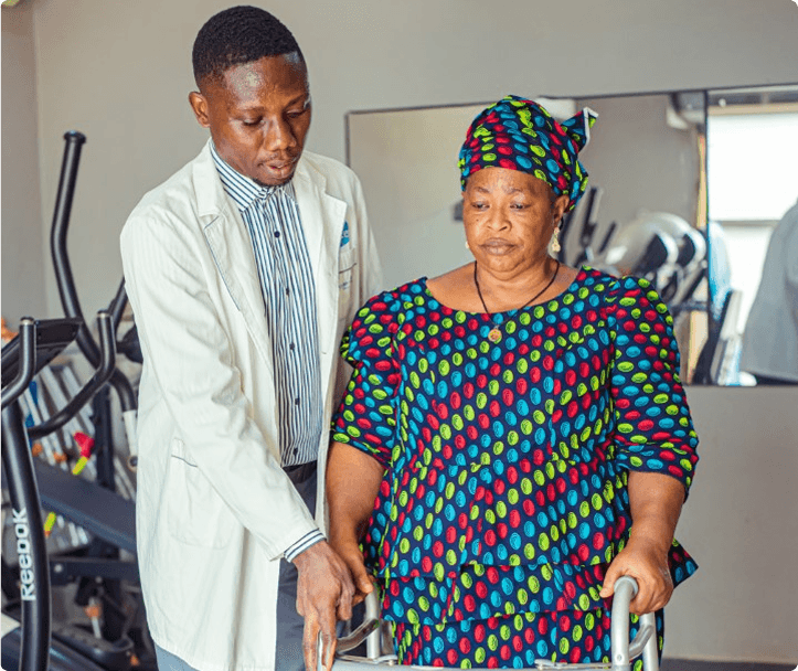 Physiotherapist supporting a patient with a walker at Niger Foundation Hospital